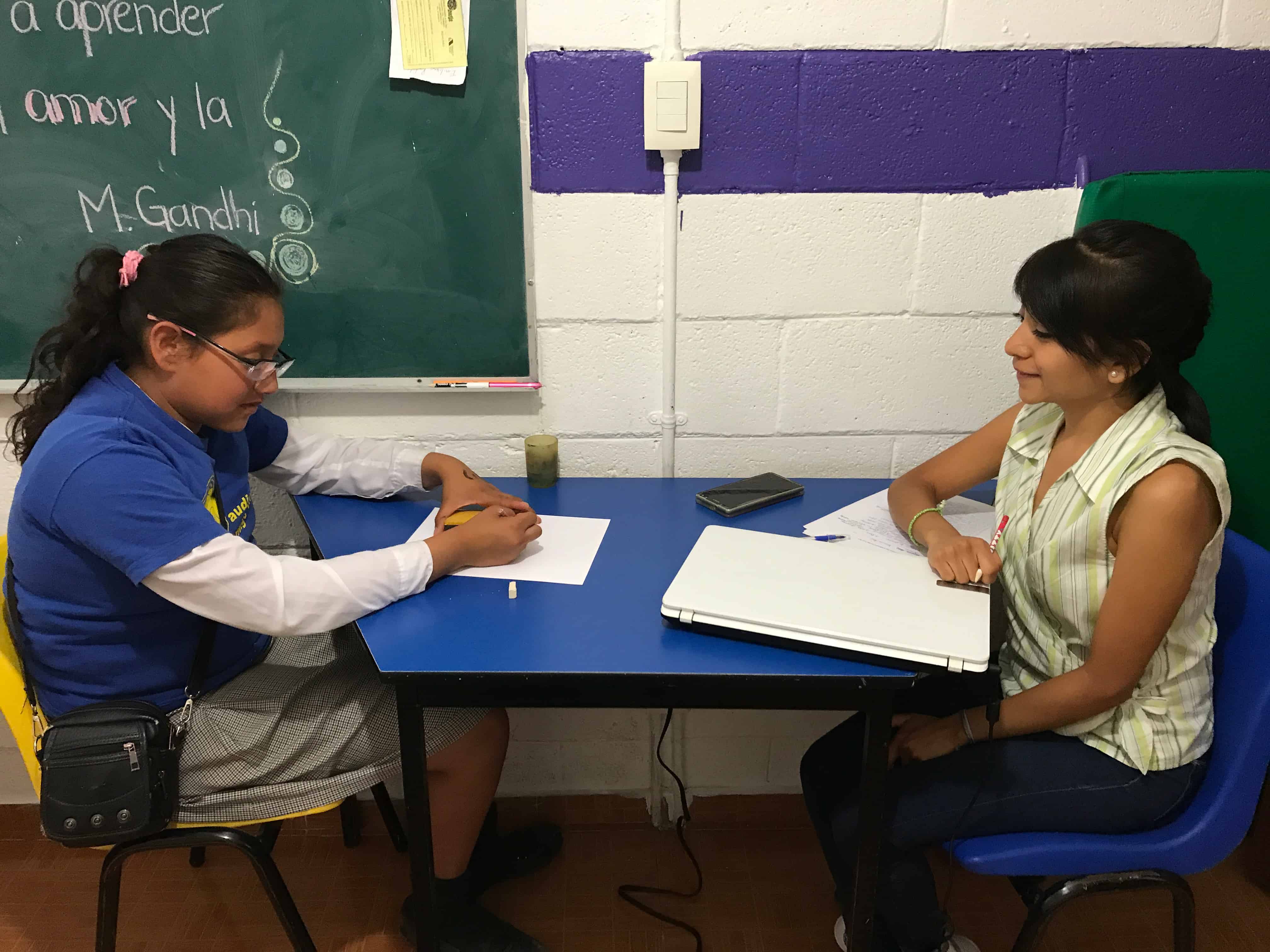Terapeuta acompañando a una niña durante una sesión de terapia en un aula